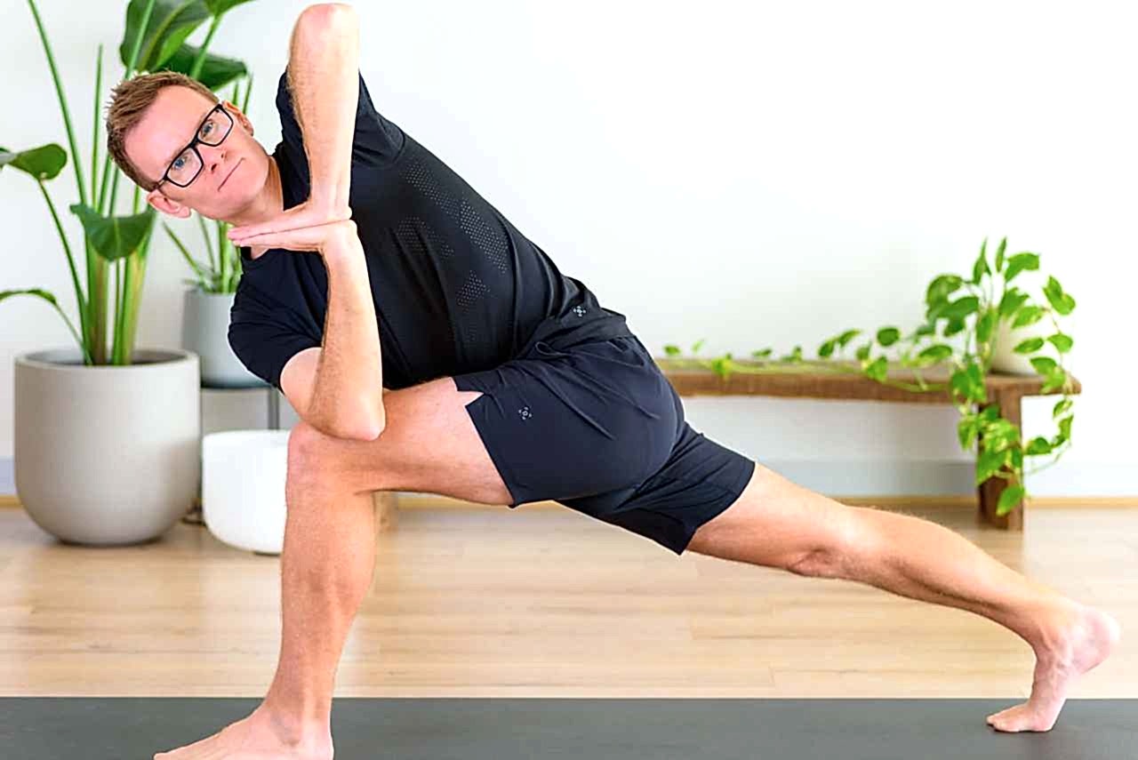 A male performing a twisting yoga pose